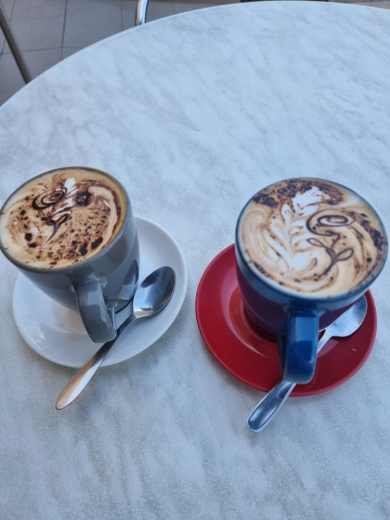 Two Vittoria coffees with detailed latte art on a marble table